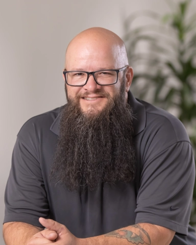 Man with glasses and beard smiling